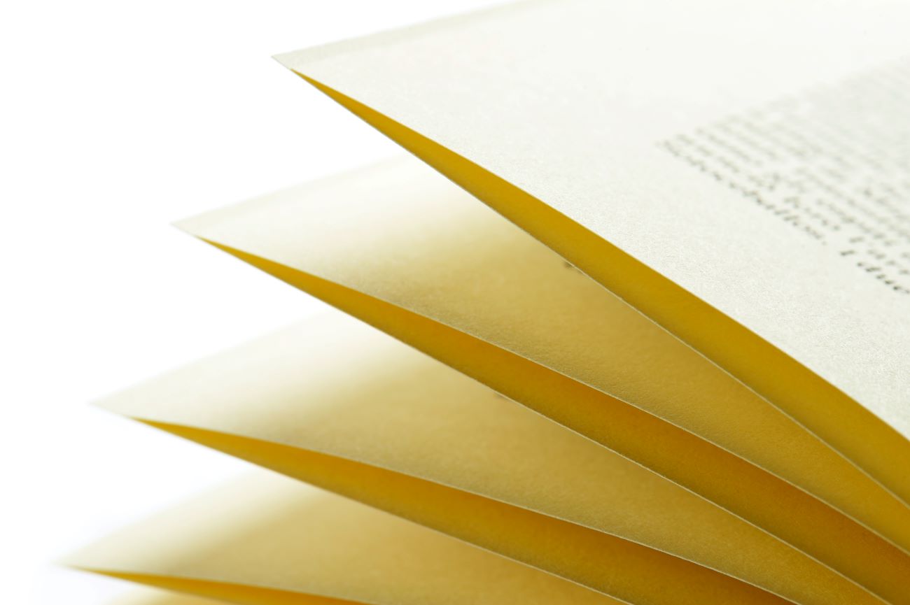 Yellow book pages being flipped on a white background